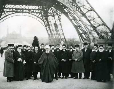 'Abdu'l-Bahá mit einer Gruppe von Bahá'í unter dem Eiffelturm in Paris, Januar 1913